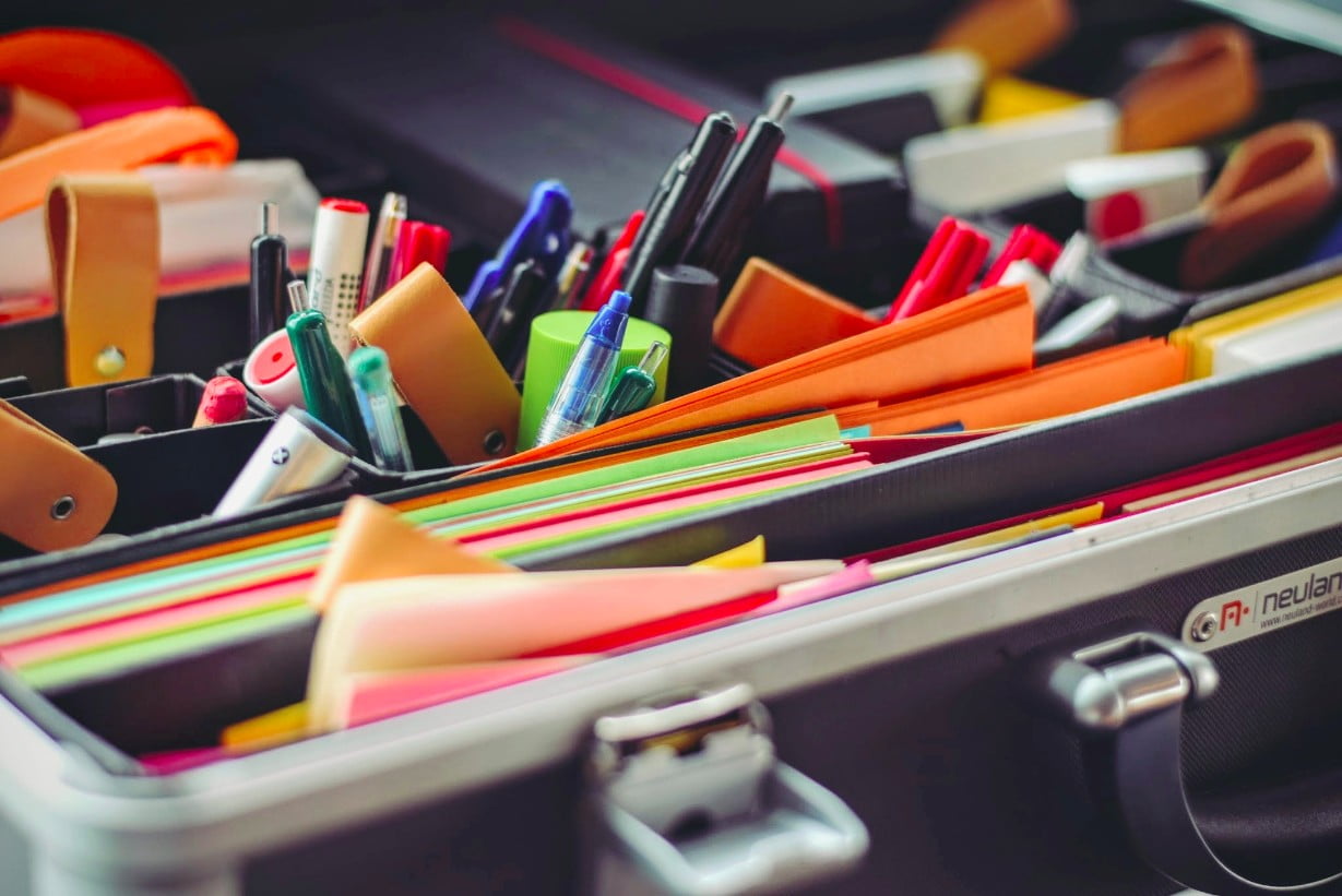 Brief case of a qualified business person filled with pens, pencils, and paper