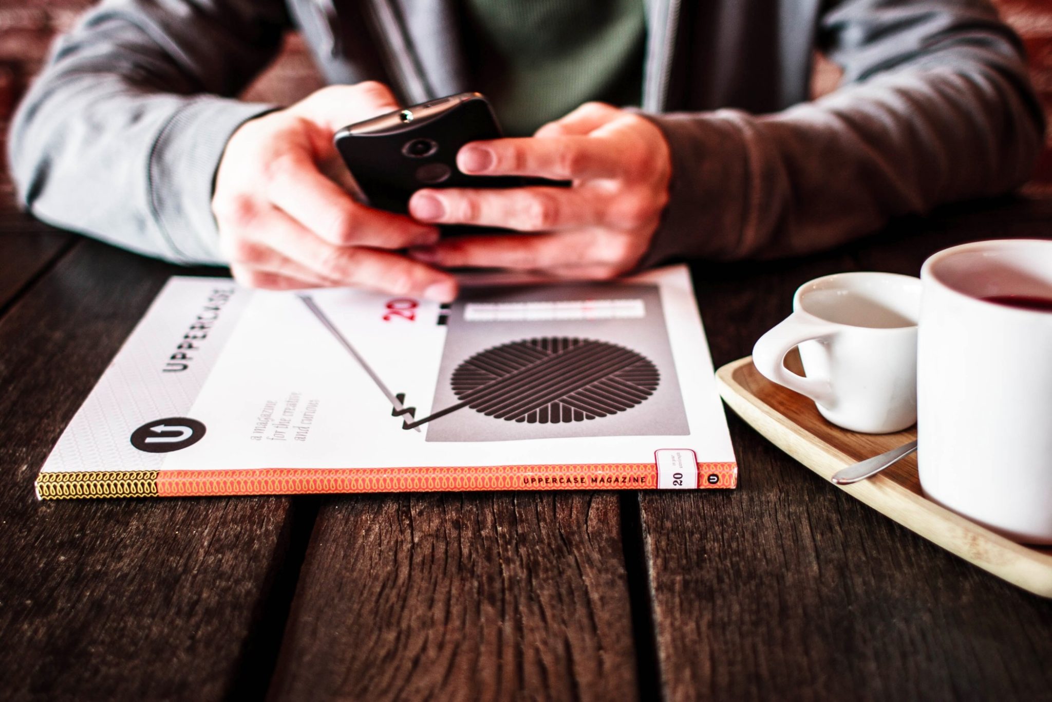 sales manager texting on his phone at a cafe