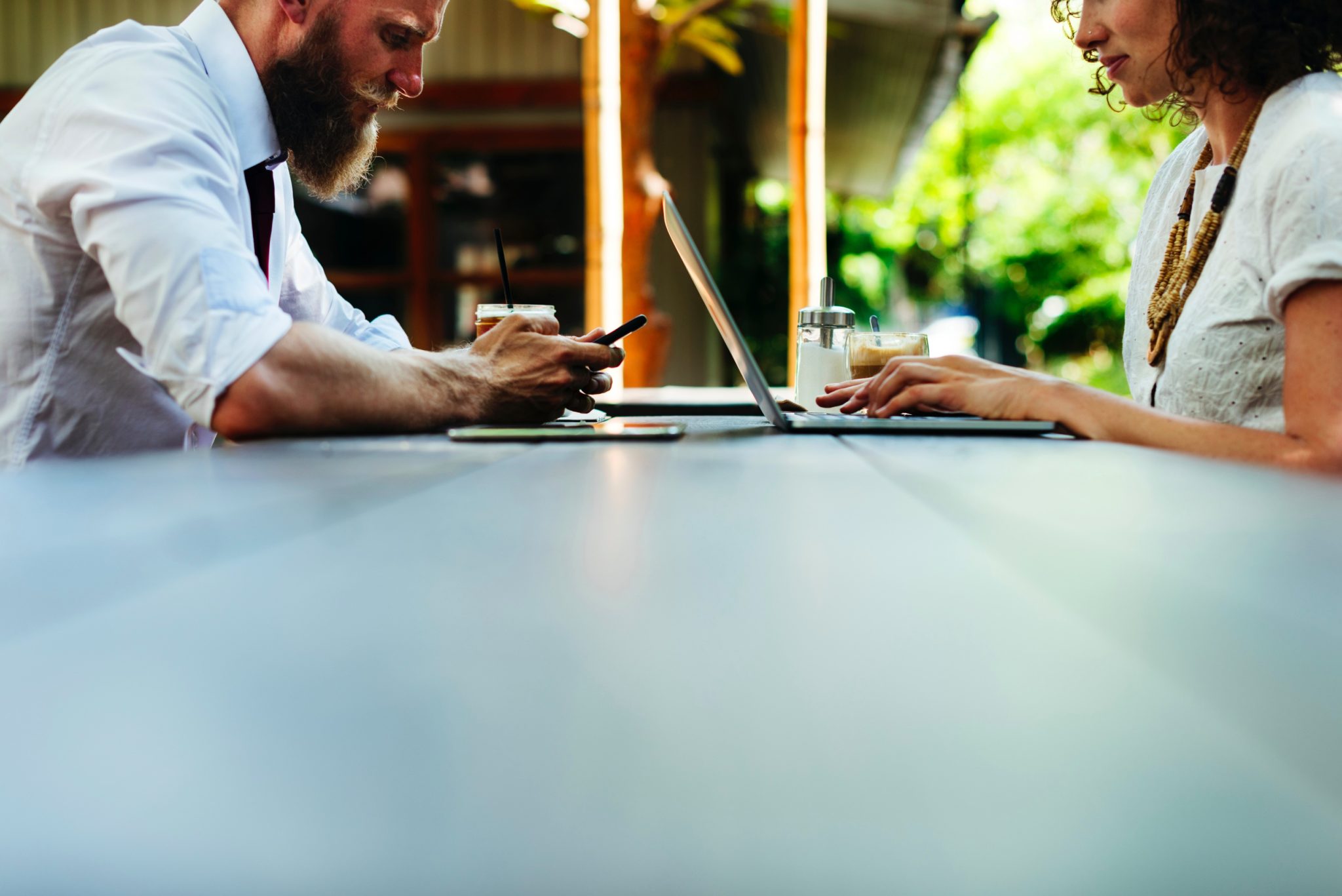 A man and women on their laptop and iphone networking